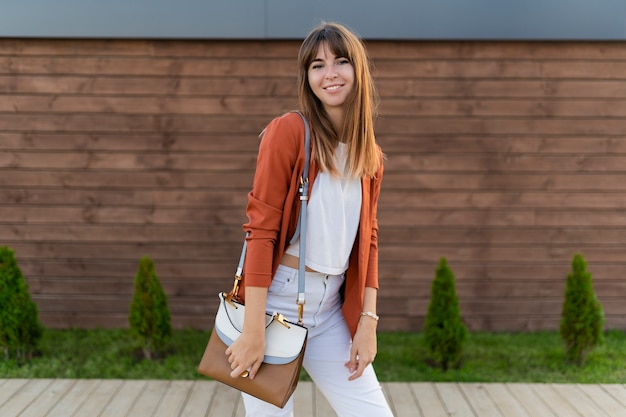 Beautiful smiling  woman in jacket posing  in the city.