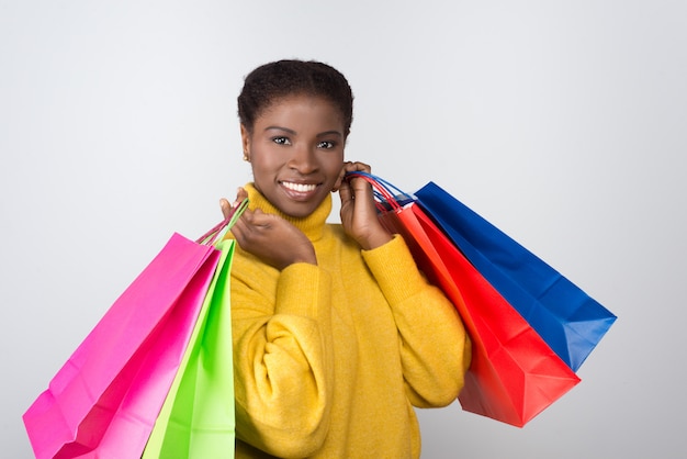 Beautiful smiling woman with colorful shopping bags on shoulders