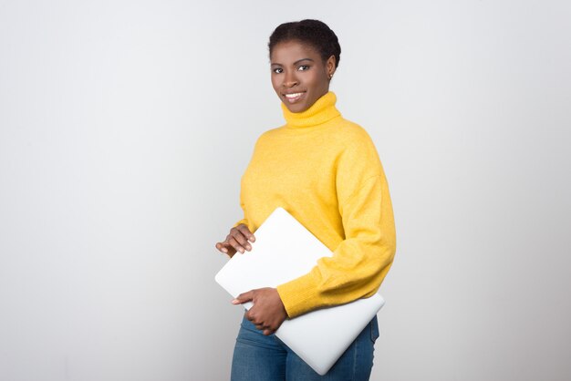 Beautiful smiling woman with laptop looking at camera