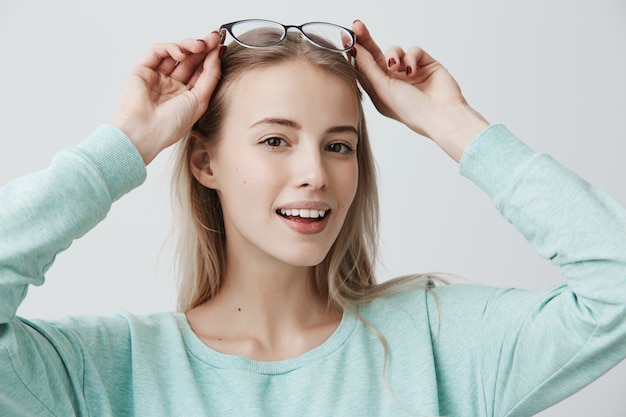 Free photo beautiful smiling woman with long blonde hair and stylish eyewear, has european appearance, looks delightfully
