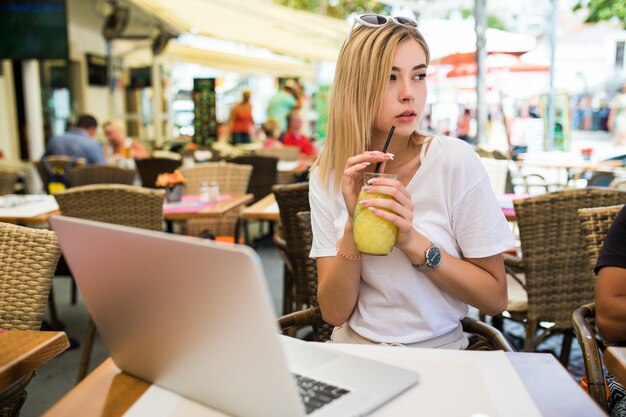 Beautiful smiling young woman sitting outdoors and chatting