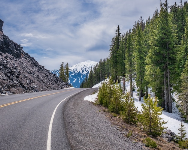 beautiful snowy rocky road around next to a forest