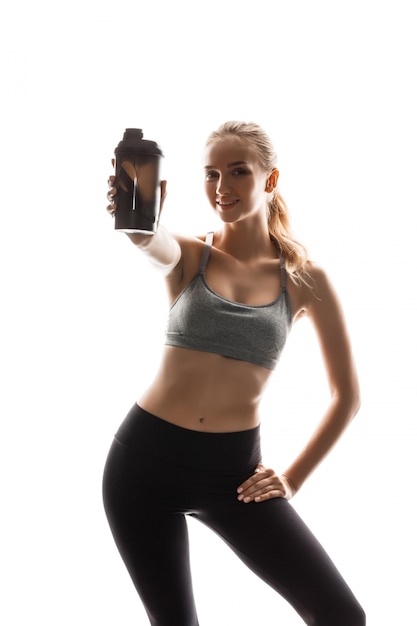 Free photo beautiful sportive woman holding bottle, posing