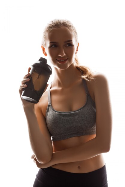 Beautiful sportive woman holding bottle, posing 