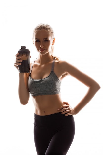 Beautiful sportive woman holding bottle, posing 