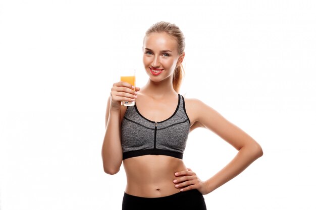 Beautiful sportive woman holding glass with juice 