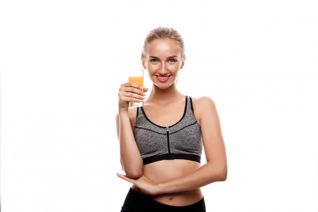 Beautiful sportive woman holding glass with juice 