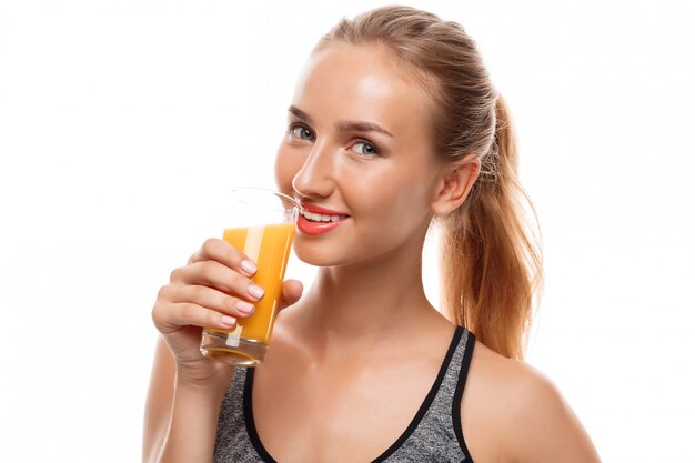 Красивая спортивная женщина, держащая стакан с соком