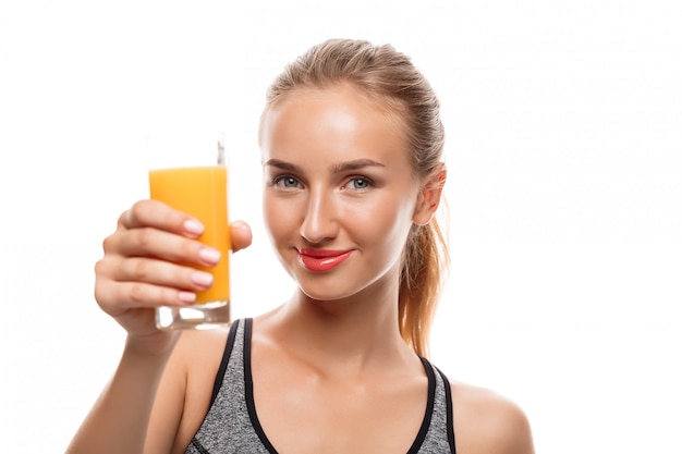 Beautiful sportive woman holding glass with juice 