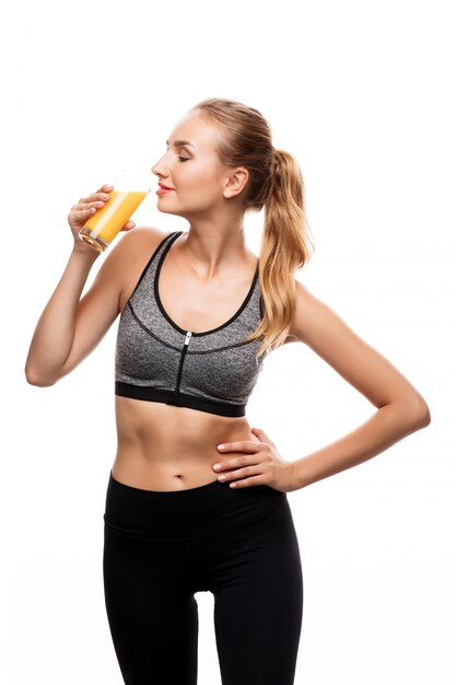 Beautiful sportive woman holding glass with juice 