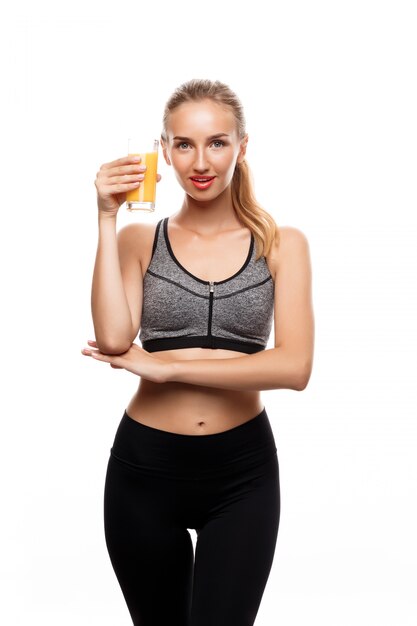 Красивая спортивная женщина, держащая стакан с соком