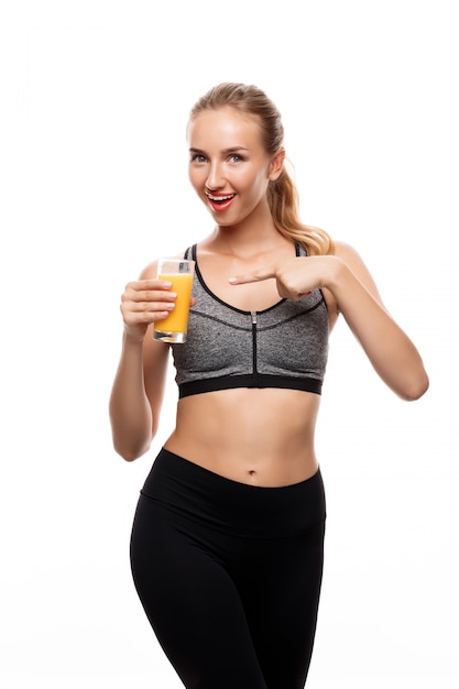 Beautiful sportive woman holding glass with juice 