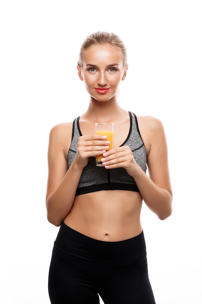 Beautiful sportive woman holding glass with juice 