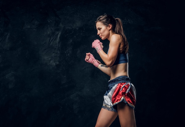 Beautiful sportive woman is warming up before training while posing for photographer.