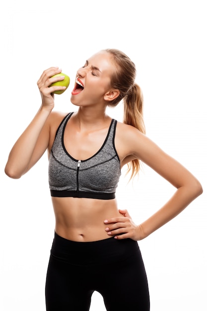 Beautiful sportive woman posing, holding apple 