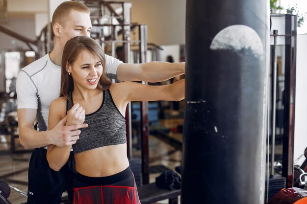 A beautiful sports couple is engaged in a gym