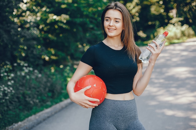 Beautiful sportsgirl in a summer sunny park