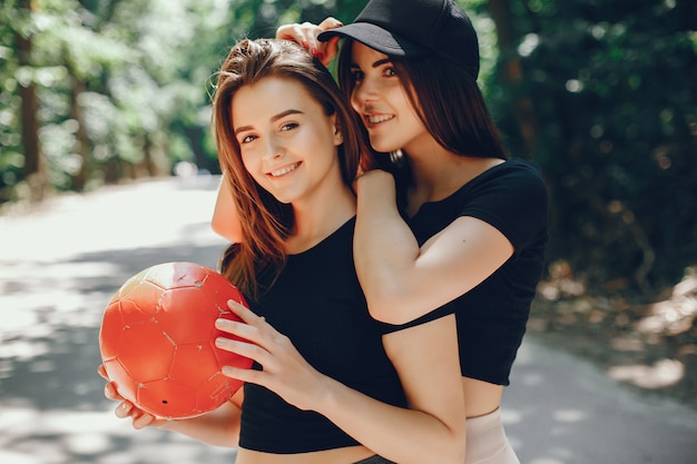 Beautiful sportsgirls in a summer sunny park