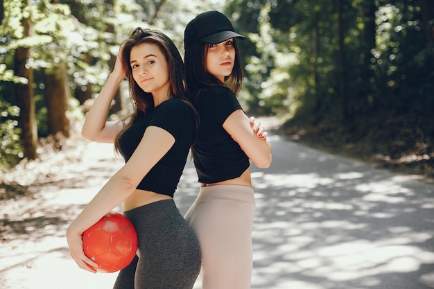 Beautiful sportsgirls in a summer sunny park