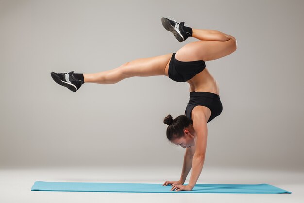 Beautiful sporty girl standing in acrobat pose