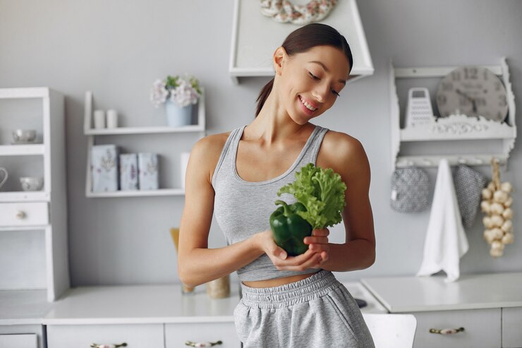 Free Photo beautiful and sporty woman in a kitchen with vegetables