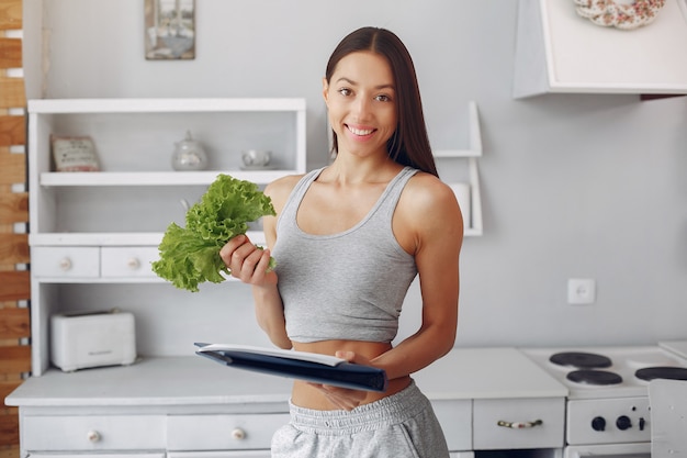 Foto gratuita donna bella e sportiva in una cucina con verdure