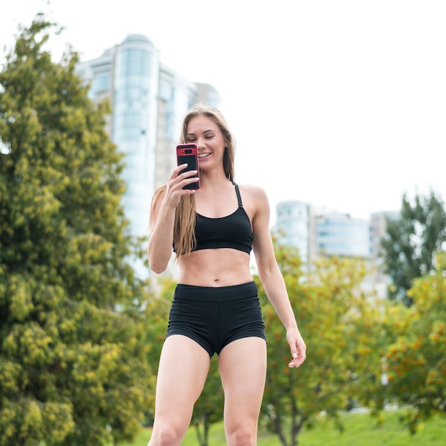 Beautiful sporty woman looking at the phone