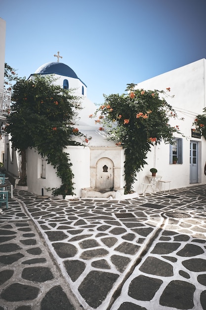 Beautiful square with white buildings and a church in Paros, Greece
