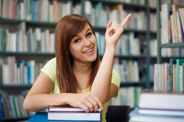 Beautiful student pointing at copyspace
