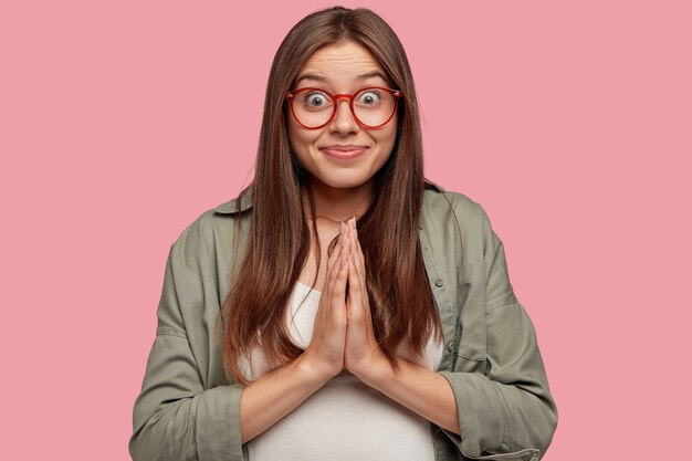 ピンクの壁にポーズをとる美しい学生