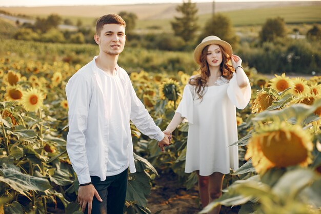 Beautiful and stylish couple in a field with sunflowers