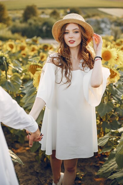 Beautiful and stylish couple in a field with sunflowers