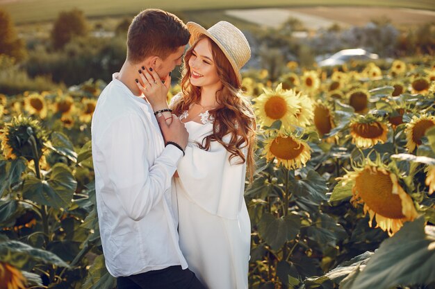 Beautiful and stylish couple in a field with sunflowers