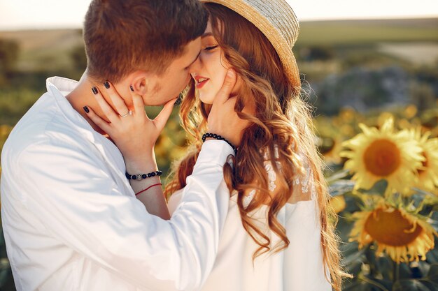 Beautiful and stylish couple in a field with sunflowers