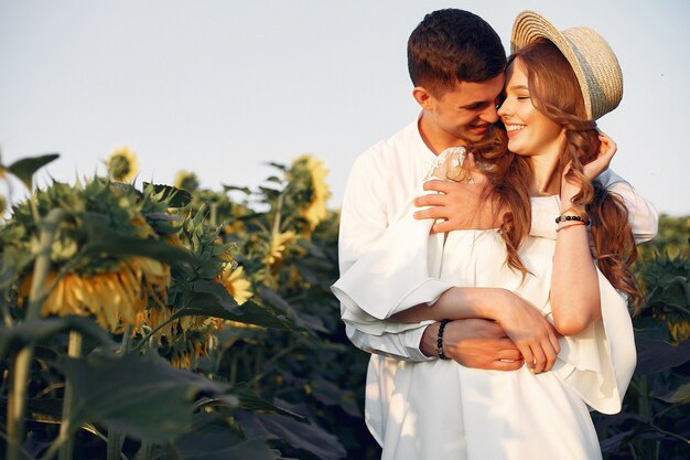 Beautiful and stylish couple in a field with sunflowers