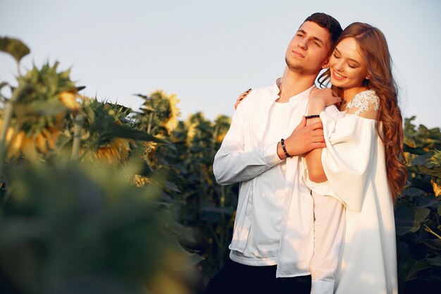 Beautiful and stylish couple in a field with sunflowers