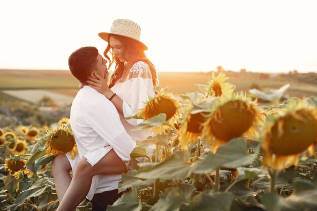 Beautiful and stylish couple in a field with sunflowers