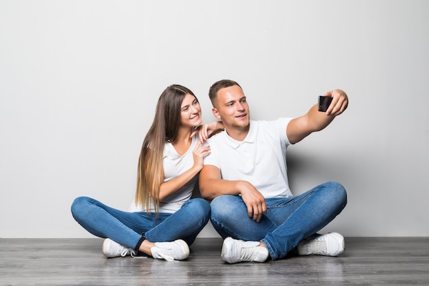 아름 다운 세련 된 커플 만들기 selfie 함께 흰색 배경에 고립