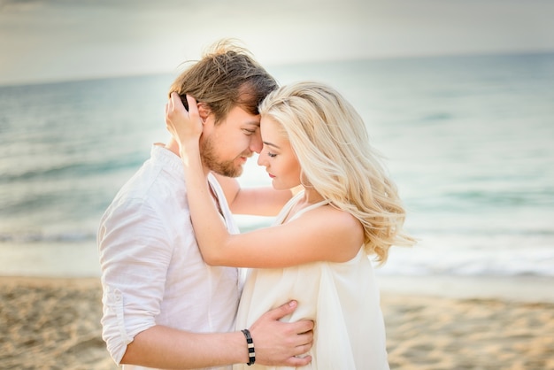 Beautiful stylish couple posing on the beach