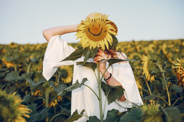 Beautiful and stylish girl in a field with sunflowers