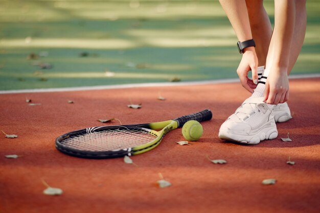 テニスコートで美しく、スタイリッシュな女の子