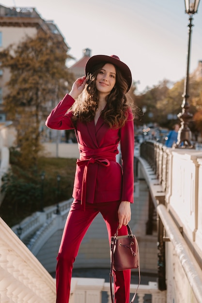 Free Photo  Cute beautiful stylish woman in purple suit walking in city  street, spring summer autumn season fashion trend wearing hat, holding purse