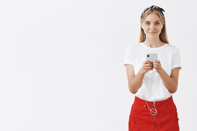 Free photo beautiful stylish young blond girl posing against the white wall