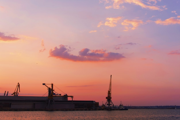 Beautiful sunset over the industrial area of a suburban city with the sun reflecting on water