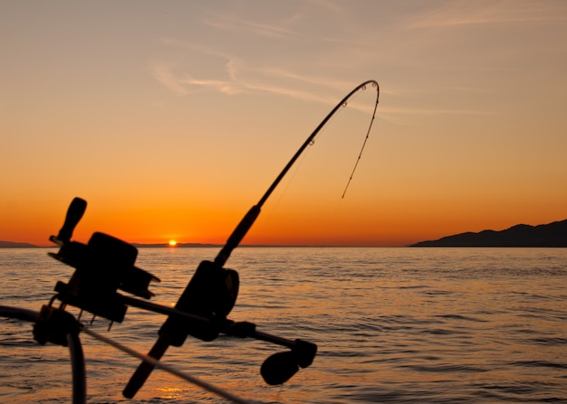 Bellissimo paesaggio al tramonto con una canna da pesca