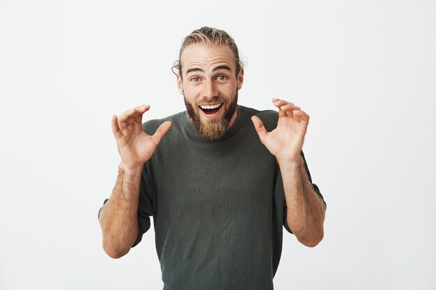 Beautiful swedish guy looking super excited and holding hands in front of him