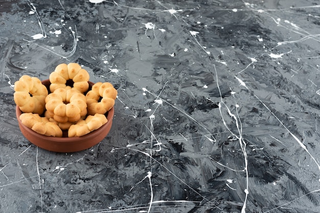 Beautiful sweet cookies for tea in a clay bowl on a marble background. 