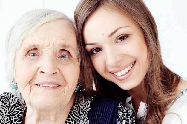 Beautiful teenager girl and her grandmother, family portrait