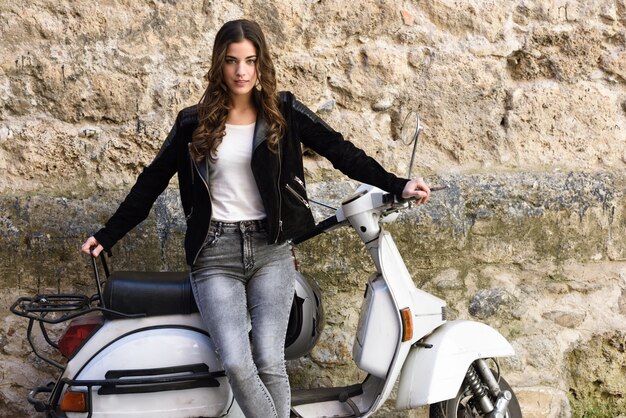 Beautiful teenager with a white scooter