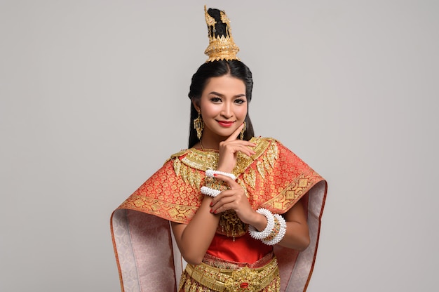 Foto gratuita bella donna tailandese che indossa un abito tailandese e un sorriso felice.